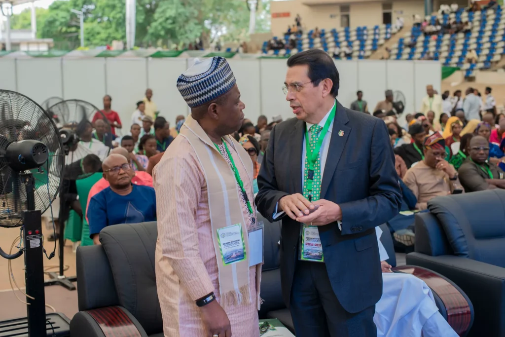 Two summit attendees speaking beside the audience seating