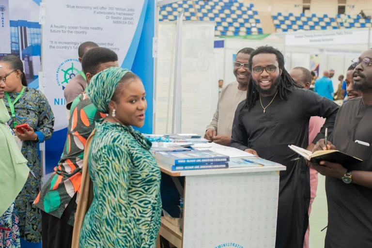 Visitors and an exhibitor in conversation at a stand