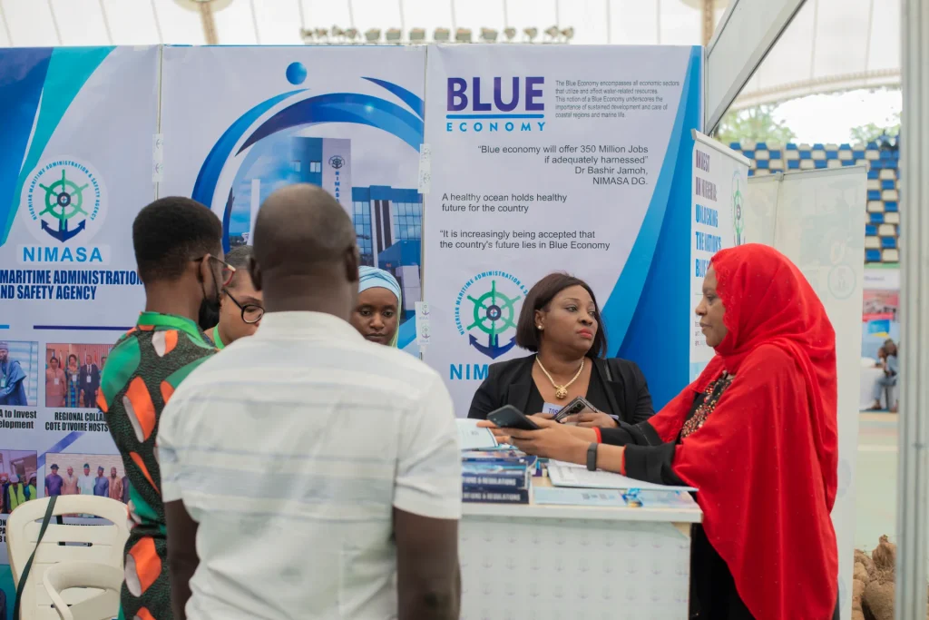 An exhibitor speaking with visitors at a branded stand